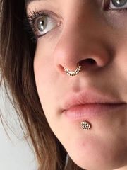 Septum piercing with a rose gold..