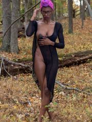 Tall ebony model with tats posing bare in